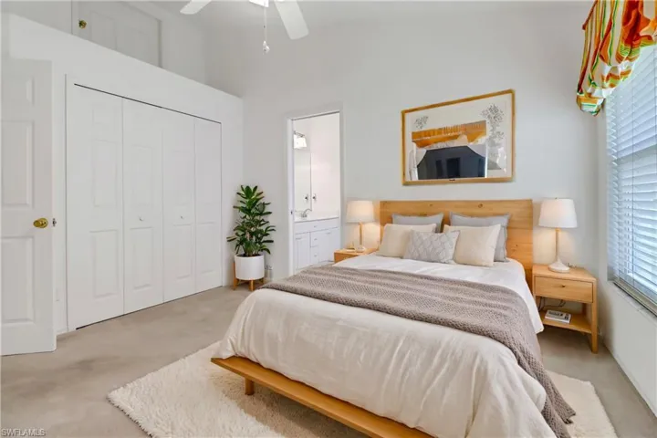 Carpeted bedroom featuring connected bathroom, a closet, and ceiling fan