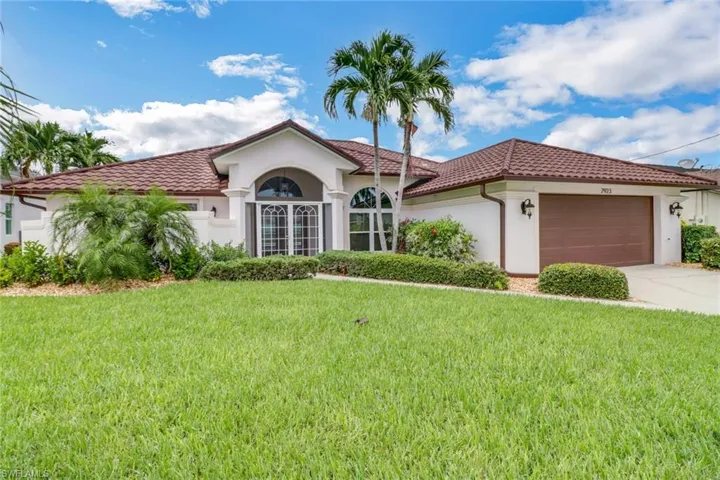 Mediterranean / spanish home with a garage and a front lawn