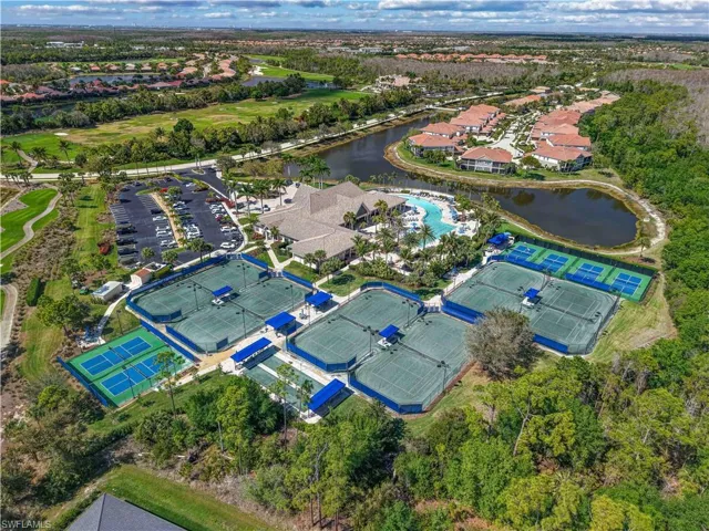 Expansive recreational area featuring multiple tennis and pickleball courts, a central clubhouse, and a resort-style swimming pool