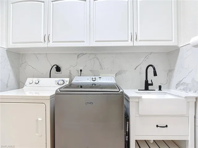 Washroom with cabinet space and washer and dryer