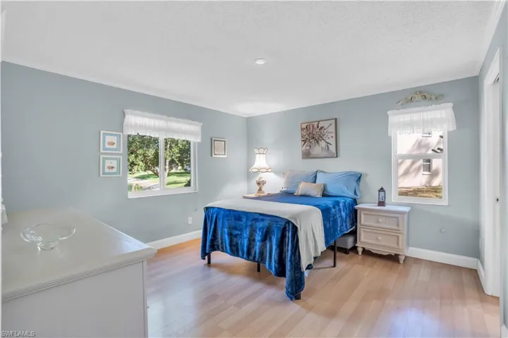 Master Bedroom with a textured ceiling, ensuite bathroom, crown molding, and light wood-type flooring