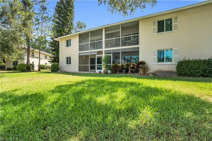 Back of property featuring a lawn
