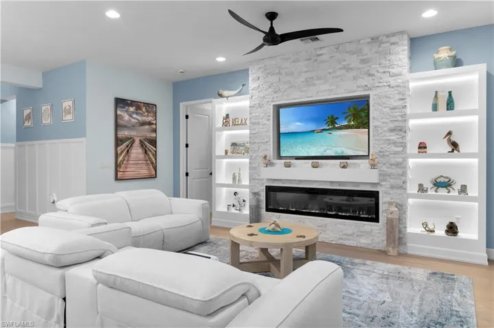 Living area with light wood-type flooring, ceiling fan, a fireplace, recessed lighting, and wainscoting