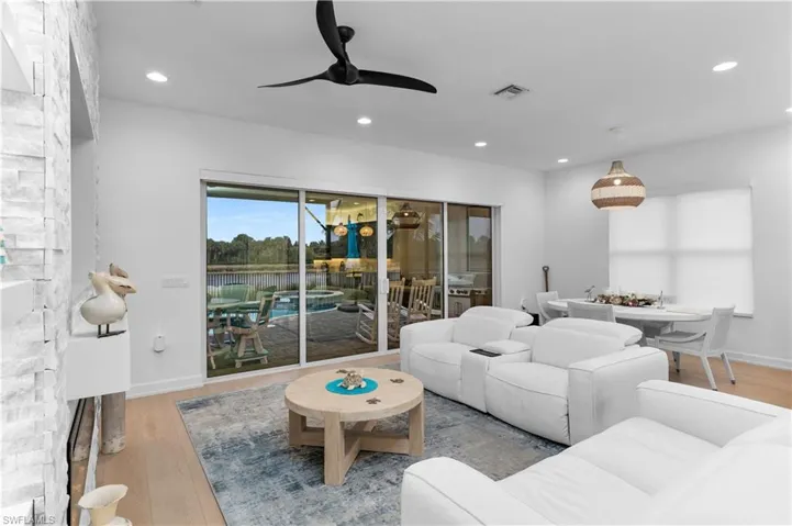 Living area featuring light wood-type flooring, a ceiling fan, and recessed lighting