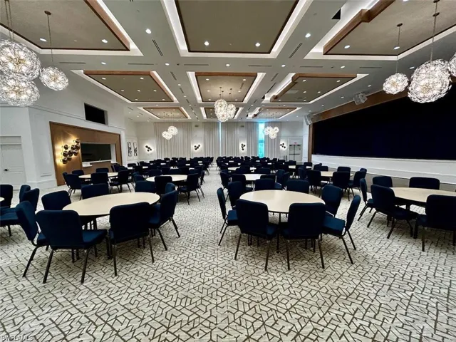 Dining area with a chandelier, light carpet, a towering ceiling, and coffered ceiling