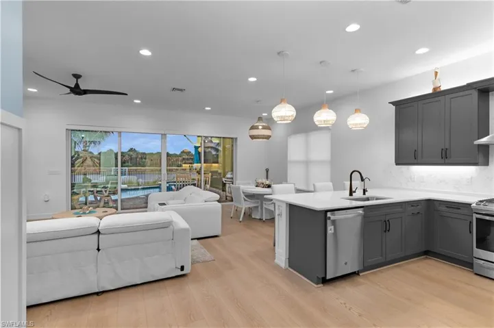 Kitchen featuring pendant lighting, stainless steel appliances, gray cabinets, recessed lighting, and open floor plan