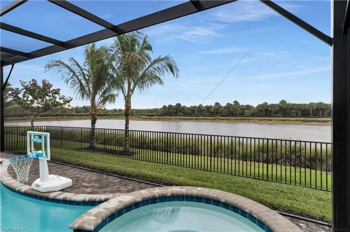 View of swimming pool with a fenced backyard, an in-ground hot tub, a patio, and a water view