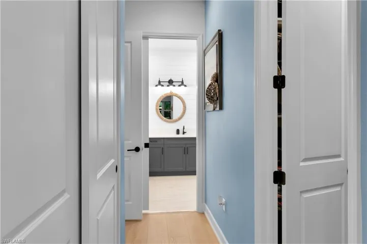 Corridor featuring light wood finished floors and a sink