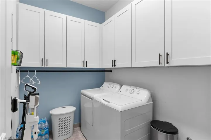 Washroom with cabinet space and washing machine and dryer