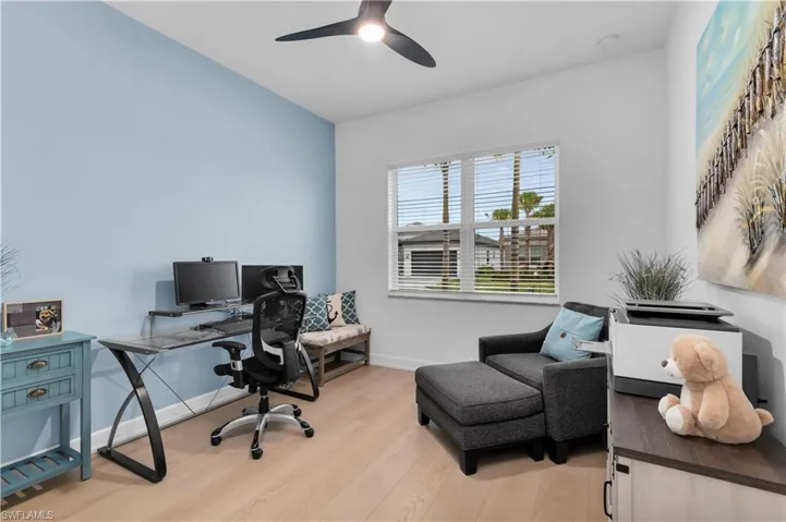 Office space with light wood-style floors and ceiling fan