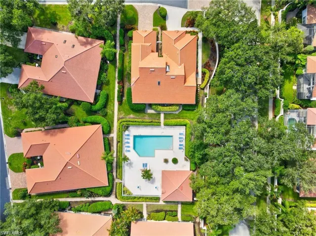 Aerial view of a residential community featuring tile roofs and lush landscaping