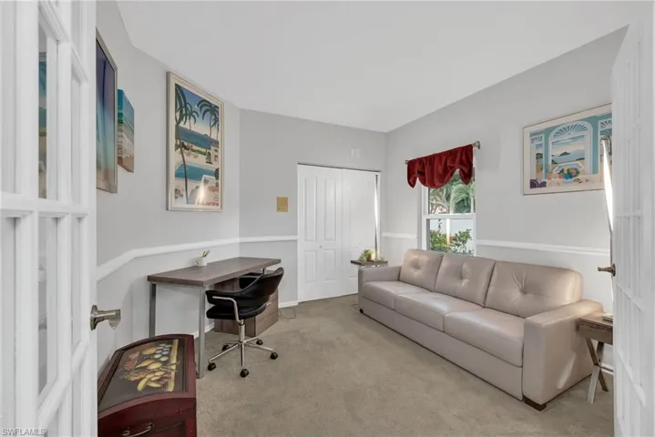 Room featuring light gray walls with white chair rail molding, a window with red valance, and a bi-fold closet door