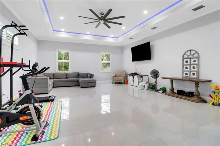 Workout room featuring ceiling fan, recessed lighting, and light tile patterned floors