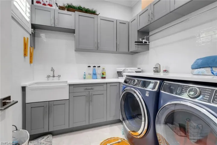 Laundry area featuring cabinet space, separate washer and dryer, and light tile patterned flooring