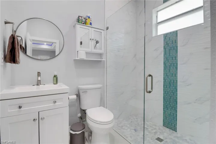 Bathroom with vanity and a marble finish shower