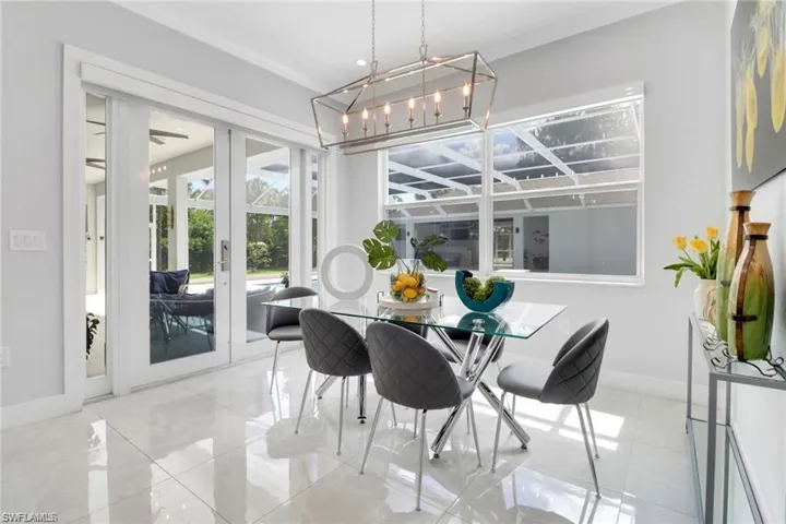 Dining area featuring french doors, suspended lighting, and crown molding