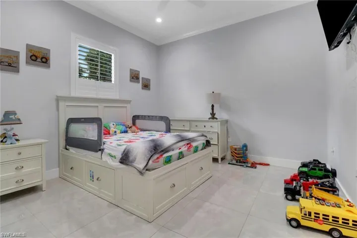 Bedroom with light tile patterned floors and ceiling fan