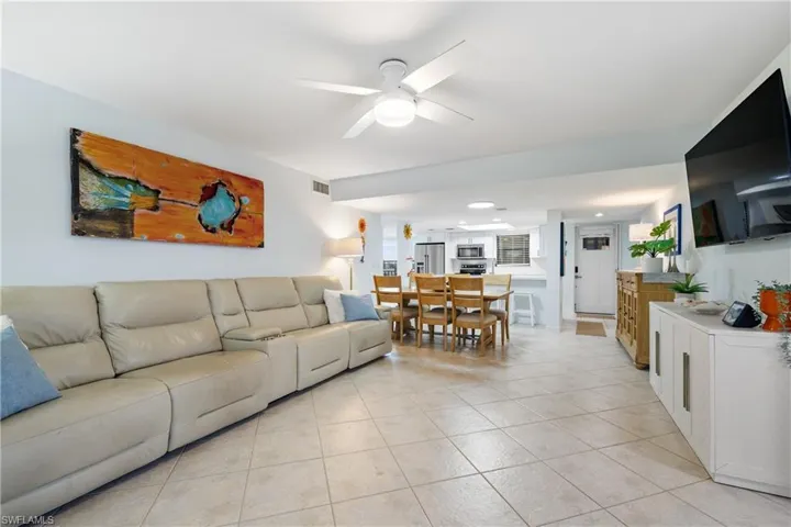 Living room with light tile patterned flooring and ceiling fan