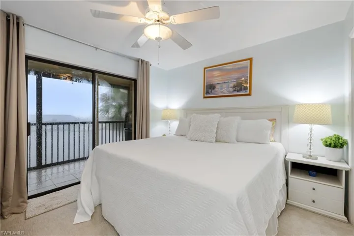 Bedroom with light carpet, ceiling fan, and access to exterior