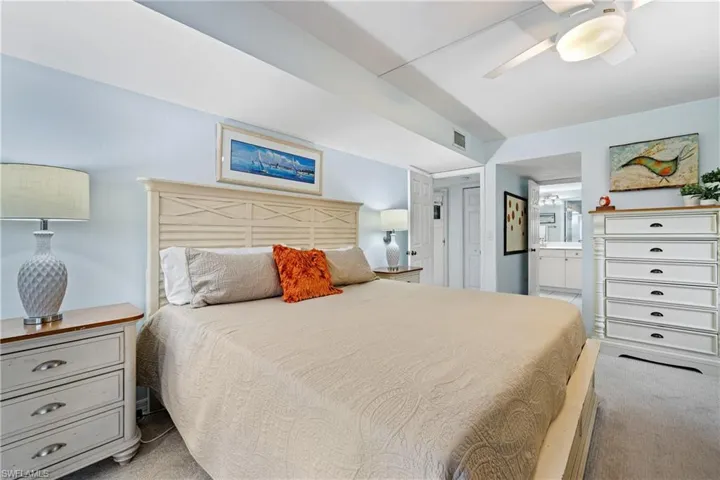 Bedroom with connected bathroom, ceiling fan, and light carpet