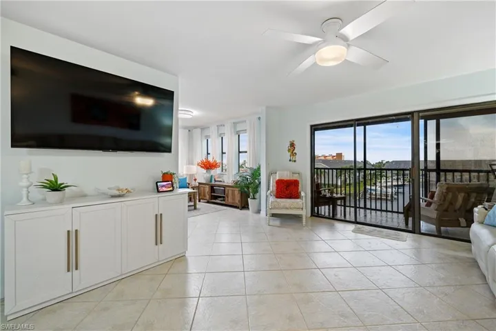 Living room with ceiling fan and light tile patterned floors