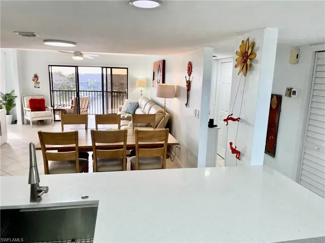 Tiled dining space with ceiling fan and sink