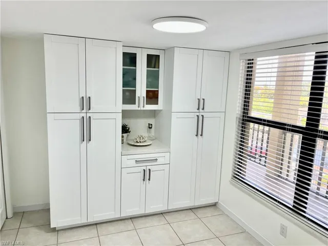 Kitchen with white cabinetry and light tile patterned floors