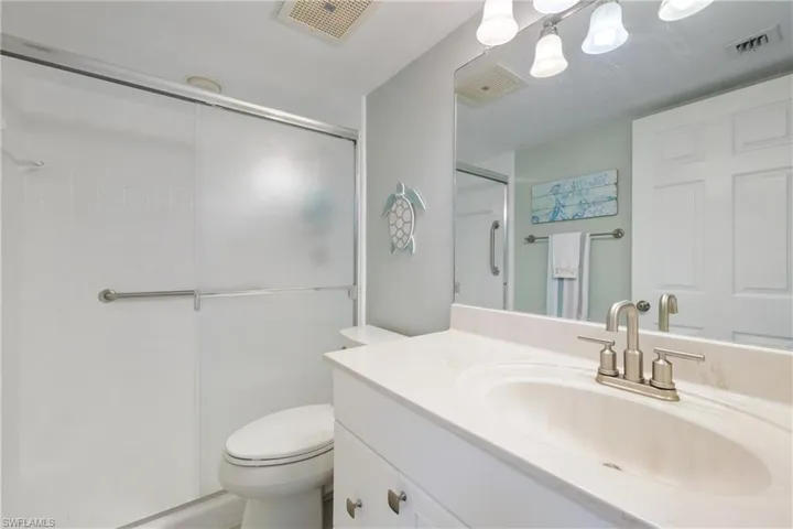 Bathroom featuring vanity, toilet, and a shower with shower door