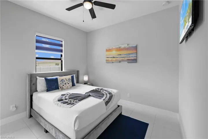 Bedroom with light tile patterned flooring and ceiling fan