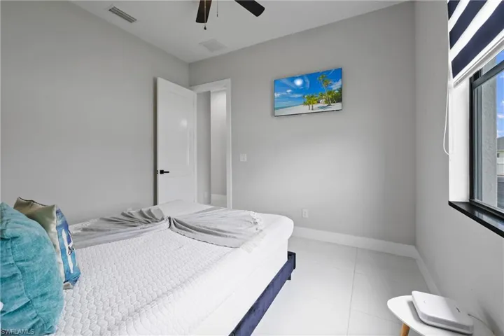 Bedroom with light tile patterned floors and ceiling fan