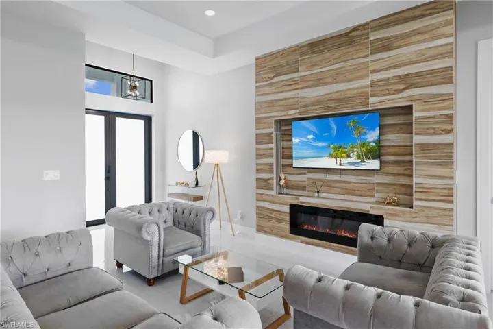 Living area with a glass covered fireplace and french doors