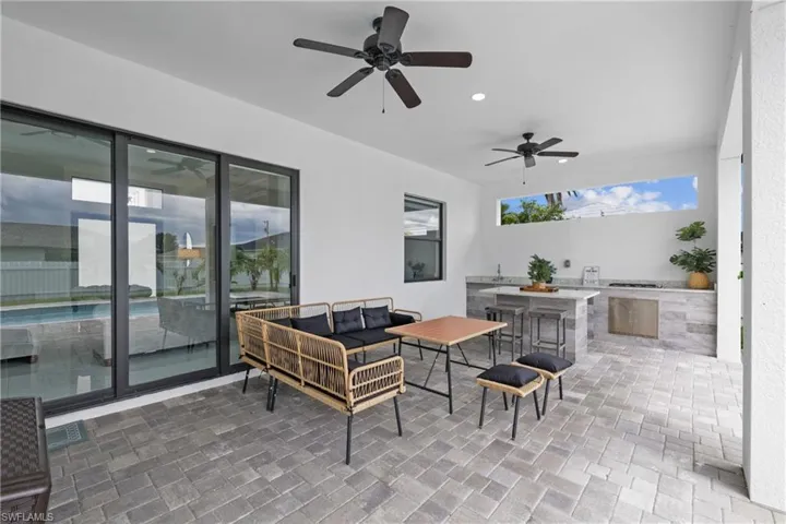 View of patio / terrace featuring outdoor lounge area, a bar, an outdoor kitchen, and ceiling fan