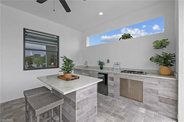 View of patio with beverage cooler, exterior kitchen, and ceiling fan