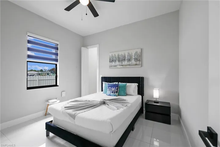 Tiled bedroom with ceiling fan and baseboards