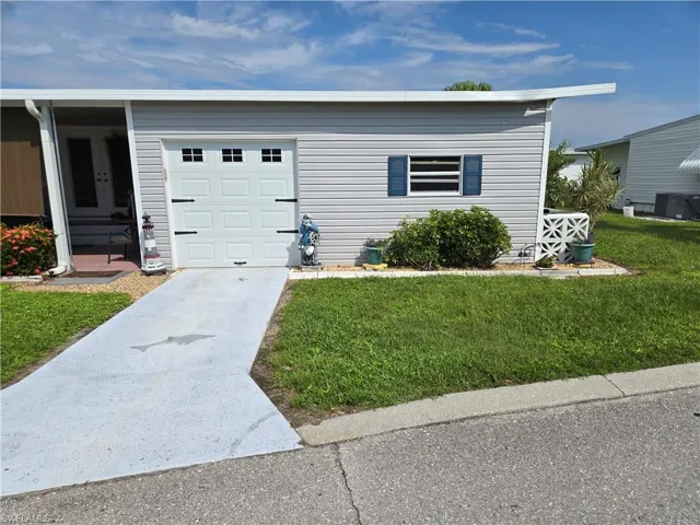 Garage featuring a lawn