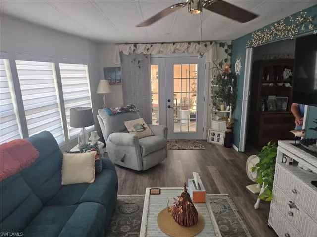 Living room featuring ceiling fan, french doors, and dark hardwood / wood-style flooring