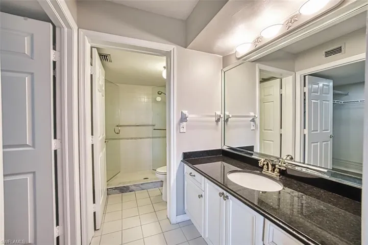 Master bathroom with vanity, a stall shower, and light tile patterned floors