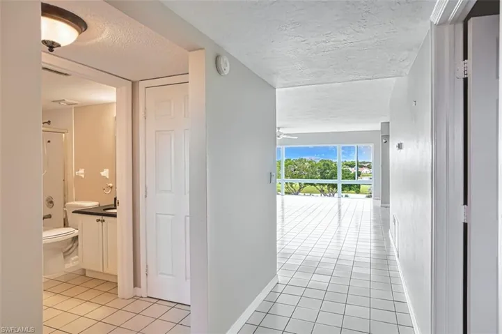 Hallway featuring a textured ceiling and light tile patterned floors