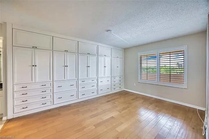 Master bedroom featuring light wood finished floors and a textured ceiling