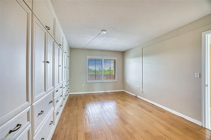 Master bedroom with a textured ceiling, light wood-type flooring, and a closet