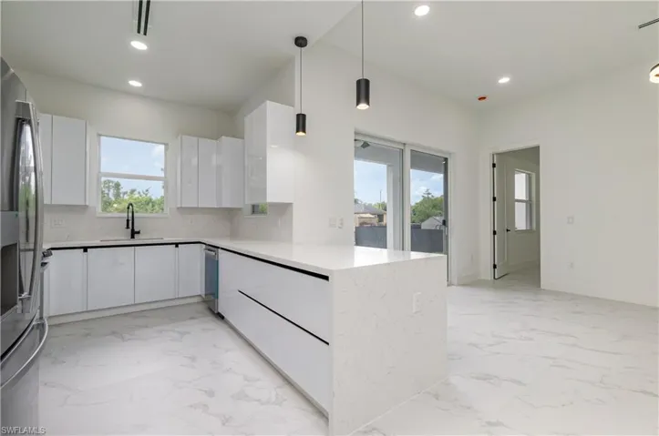 Kitchen with a peninsula, modern cabinets, pendant lighting, and recessed lighting