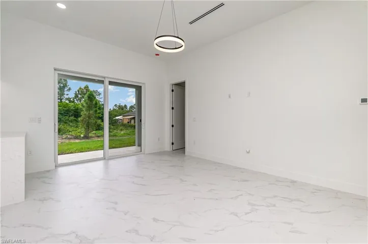 Empty room featuring light marble finish floors and recessed lighting