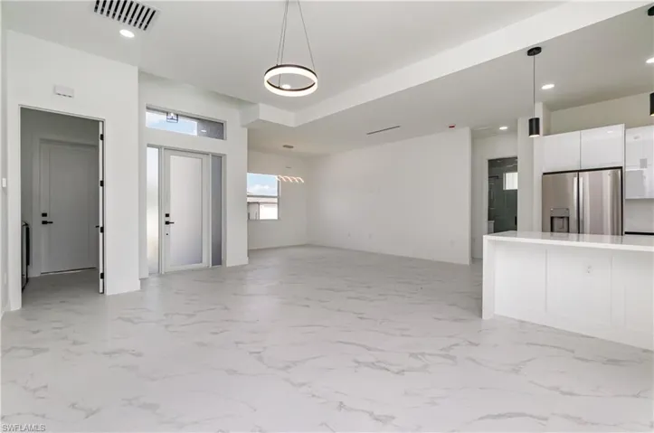 Unfurnished living room featuring recessed lighting and light marble finish flooring