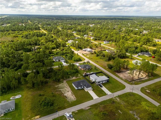 Aerial perspective of suburban area featuring a heavily wooded area