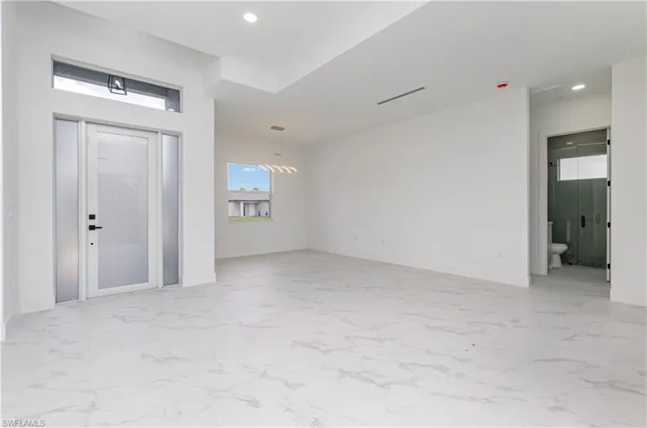 Foyer entrance with light marble finish flooring and recessed lighting
