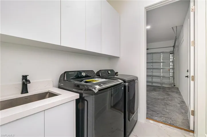 Washroom featuring cabinet space and washing machine and clothes dryer