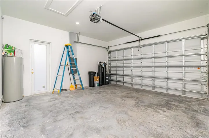 Garage featuring water heater and a garage door opener