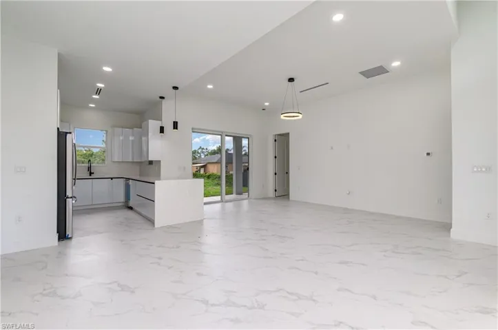 Unfurnished living room with light marble finish flooring and recessed lighting