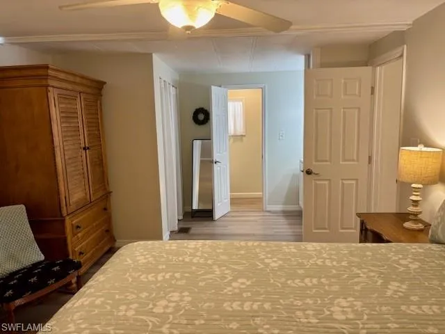 Bedroom featuring baseboards, a ceiling fan, and wood finished floors