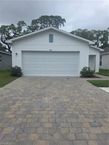 Ranch-style house with driveway, stucco siding, and a garage